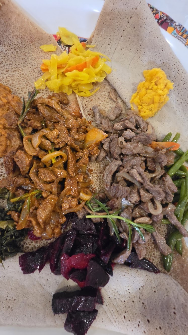 Ethiopian meat and vegetable combination platter on injera